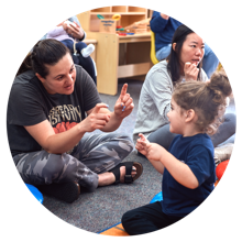 A parent playing a gesture game with their young child.